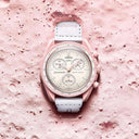 Pink and white chronograph men's wristwatch with textured dial on a pink lunar surface.